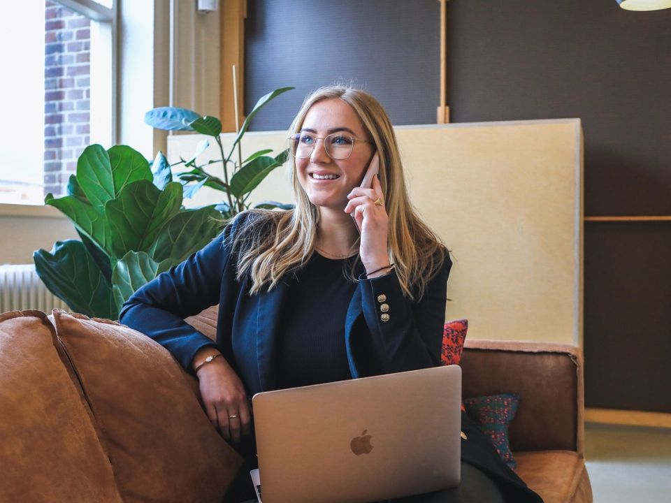 A woman on a call with her laptop in a bright office