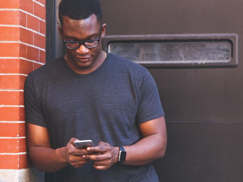 A man texting on a city street
