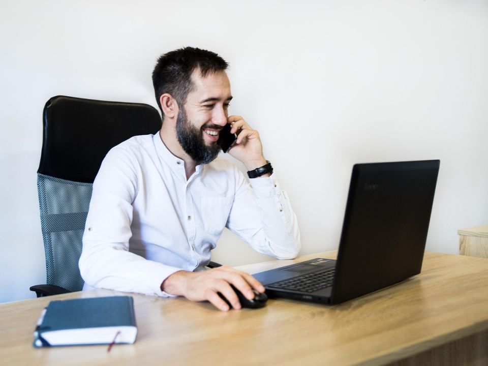 A man on a phone call at his desk