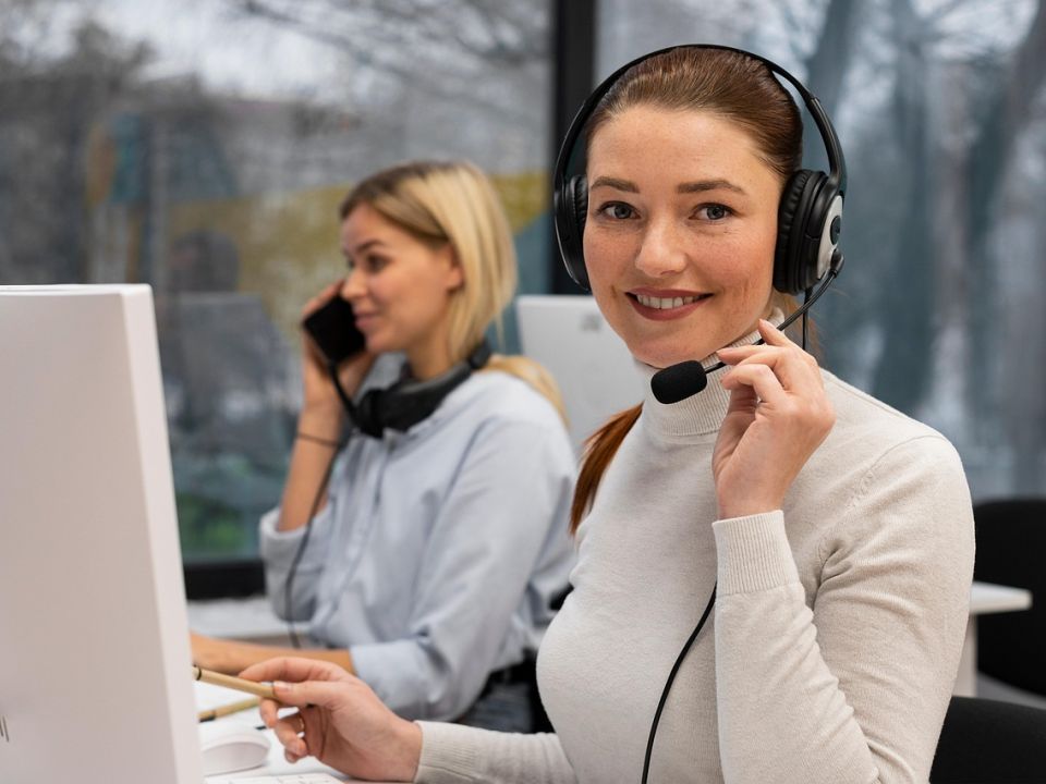 A smiling woman wearing a headset at work