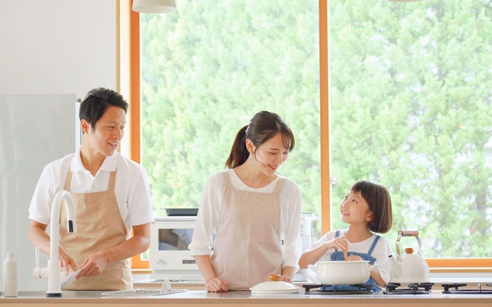 A family cooking breakfast together in a bright kitchen