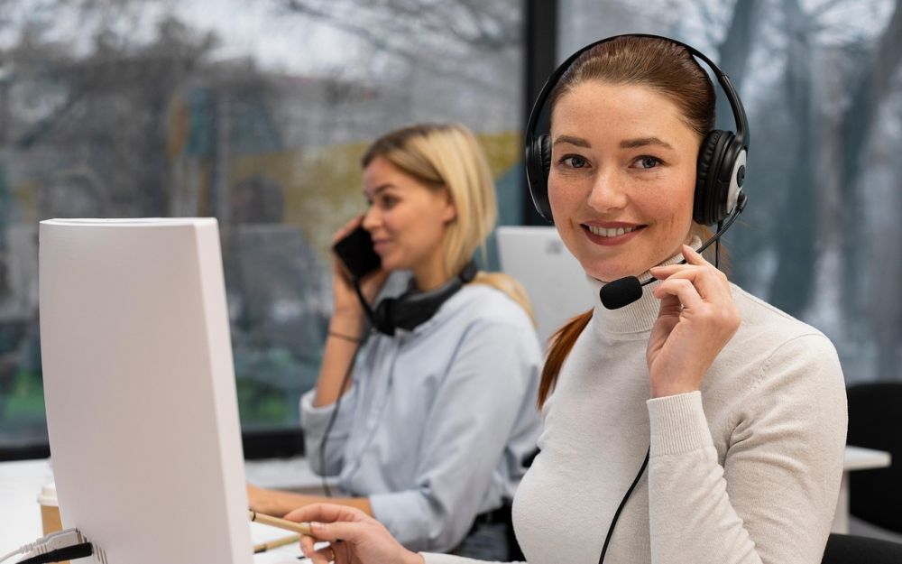 A support agent wearing a headset, smiling