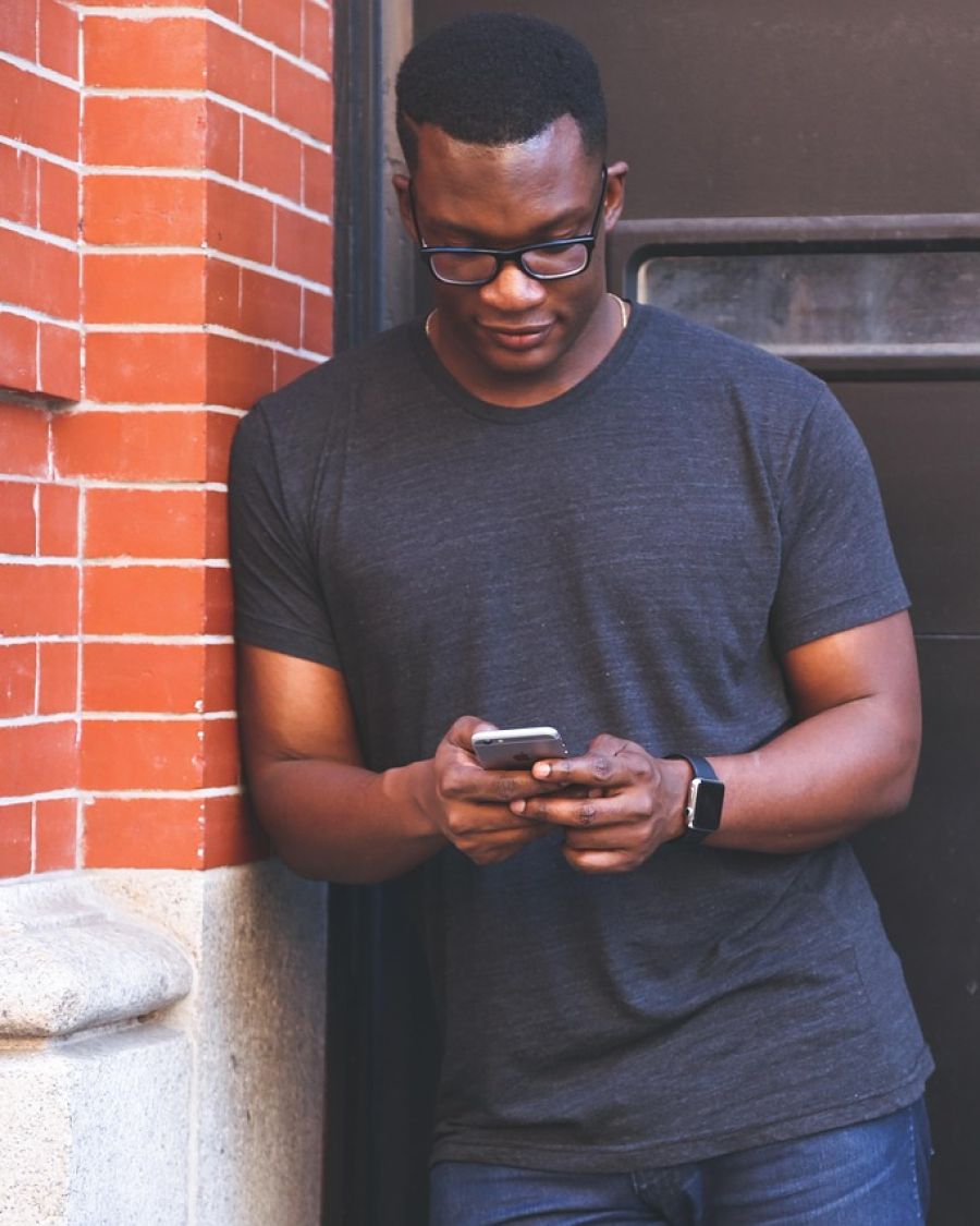 A man texting on his phone on a city street